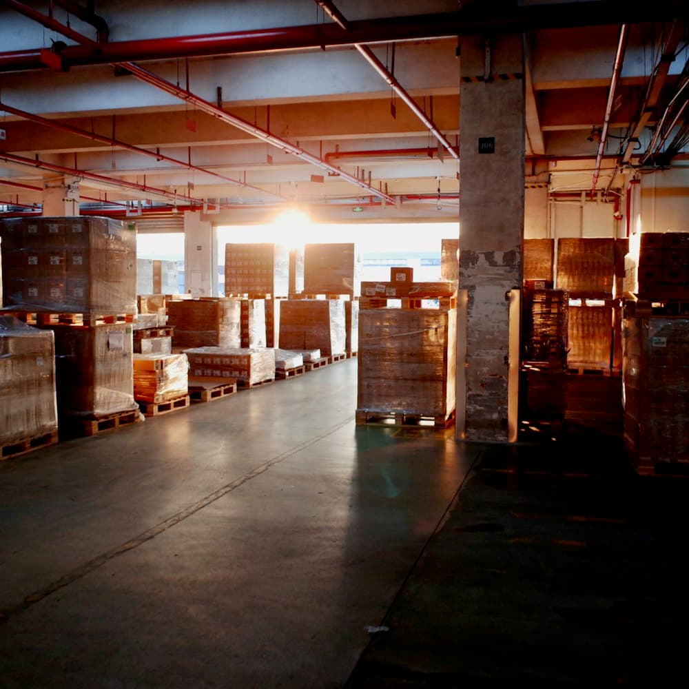 Warehouse aisle stacked with wrapped inventory pallets